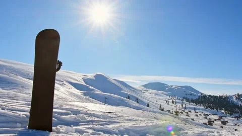 Black base of snowboard in a snow with white mountains in the background. C.. Stockbeeldmateriaal 232178084