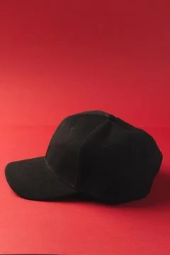 Black baseball cap and copy space on red background Stock Illustration