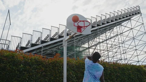 Black basketball player doing a throw with one hand but missing Vidéo 226986155