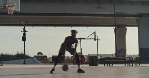 Black basketball player doing tricks near hoop Stock Footage 213308749