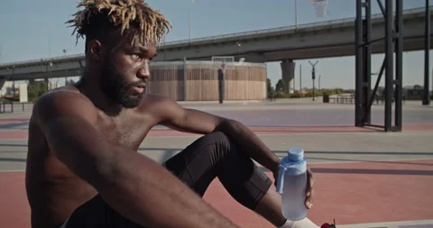 Black basketball player taking break on court Stock Footage 213314322
