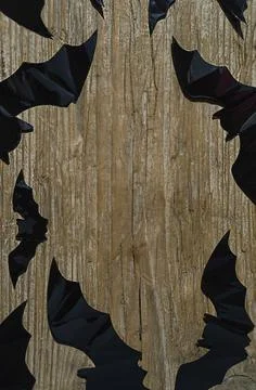 Black bats on a wooden background with copy space in the center Stock Photos