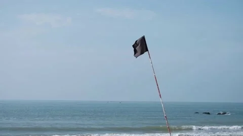 Black beach flag is waving on the beach swimming is not safe to swim Stock Footage 137392943