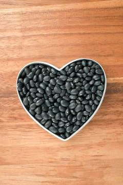 Black beans on a heart shape container Stock Photos