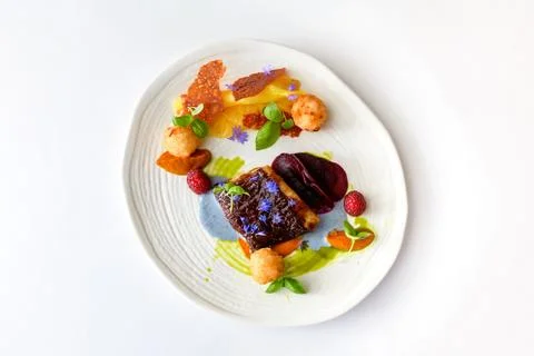 Black beef steak with beetroot slices, raspberries, sauce Stock Photos