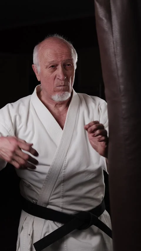 A black belt trainer performs circular punches on a machine Stock Footage 309741923