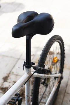 Black bicycle saddle from a high angle, with a blurred rear wheel Stock Photos