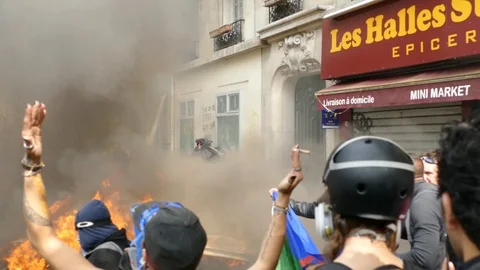 Black bloc protesters putting diverse objects in the flames Stock Footage 107859265