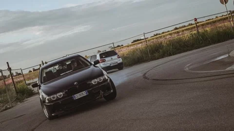 Black bmw drifting and burning tires in front of crowd Stock Footage 313382990