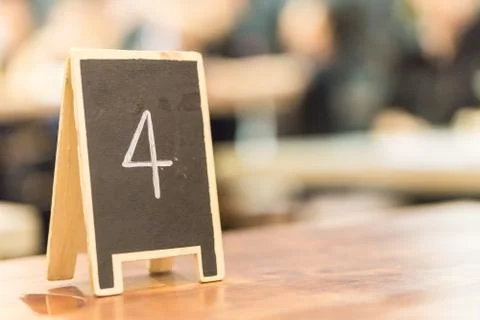 Black board number four on the table in restaurant with copy space for text., Stock Photos