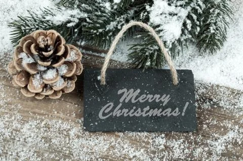 Black board of slate on old rustic wooden background, with snow Stock Photos