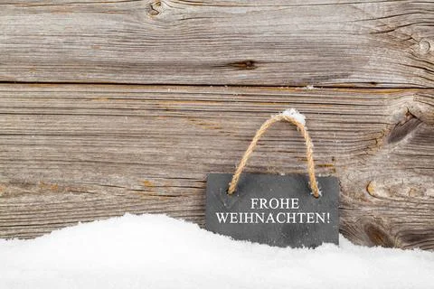 Black board of slate on old rustic wooden background, with snow Stock Photos