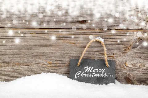 Black board of slate on old rustic wooden background, with snow Stock Photos