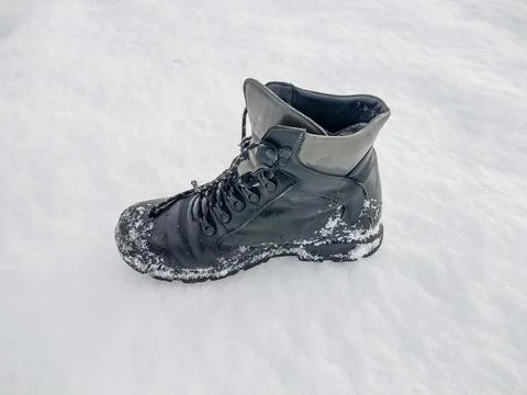 Black boot on snow in the winter Fotos de archivo