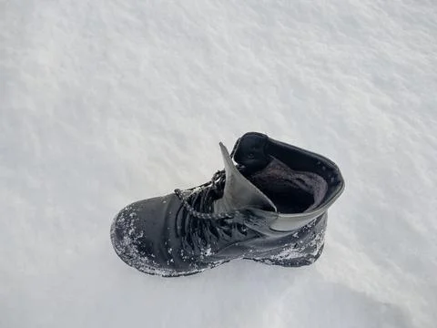 Black boot on snow in the winter 库存照片