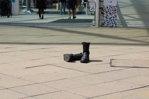 Black boots left on paving Stock Photos
