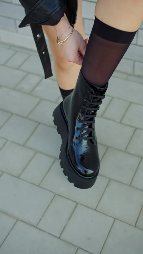 Black boots with sheer socks on pavement Stock Footage 320788182