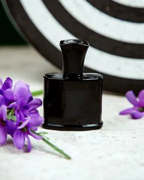 Black bottle of parfum on the table Stock Photos
