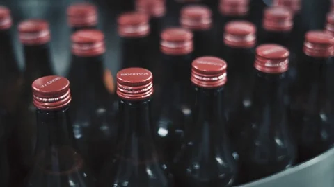 Black bottles with red caps being arranged by machine at medical factory. Stock Footage 119286577
