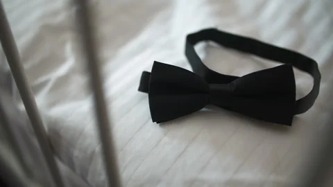 Black bow tie resting on rumpled white bedding Vídeo Stock 336467018