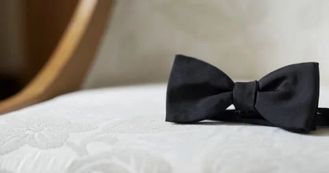 Black bow tie on white pillow in soft interior light Vídeo Stock 336469551