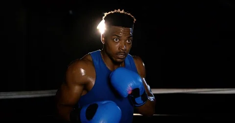 A black boxer practices punching in an empty boxing ring Stock Footage 83376953