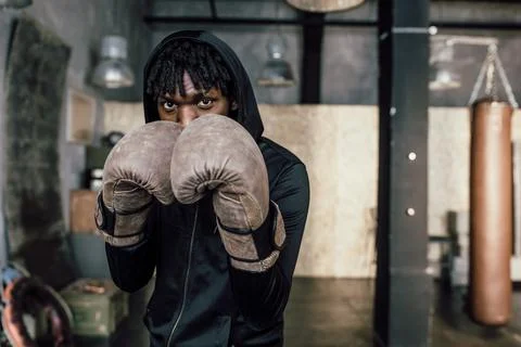 Black boxer. Punch to the camera, close-up Stock Photos