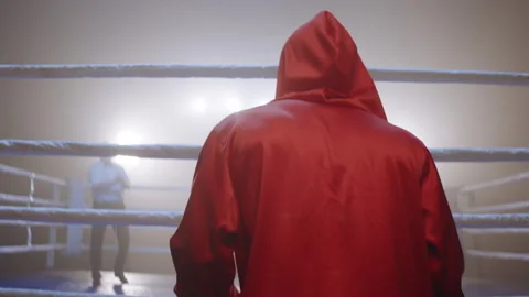 Black boxer in red robe approaching the ring with his opponent in it Stock Footage 282985956
