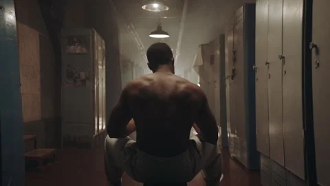 Black boxer sitting on a bench in the locker room Stock Footage 282988536