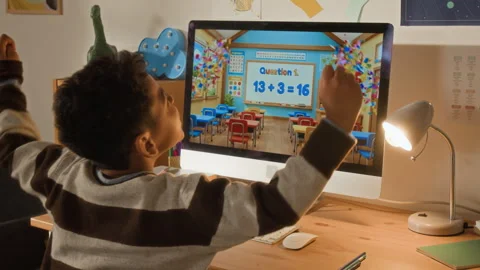 Black Boy Cheering while Doing Math Sums on Online App Stock Footage 334973300