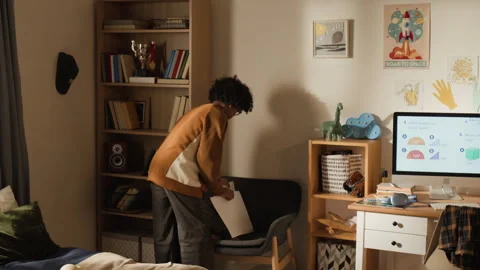 Black Boy Hanging School Timetable on Wall to Replace Superhero Poster Stock Footage 334971058