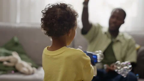 Black Boy Playing with Soap Bubble Guns with Father at Home Stock Footage 345491583