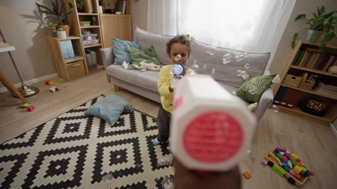 Black Boy Playing with Soap Bubble Guns at Home with Father Stock Footage 345494227