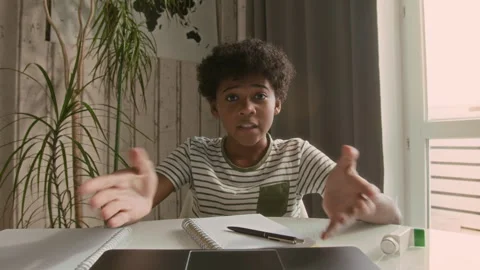 Black Boy Taking Notes and Talking with Online Tutor via VideoCall Stock Footage 294299933