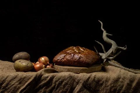 Black bread and vegetables on a black background. Borodino bread. Homemade bakin Stock Photos