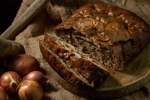 Black bread and vegetables on a black background. Borodino bread. Homemade bakin Stock Photos