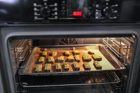 Black bread with cheese in the oven. Roasted bread with cheese and spices, co Stock Photos