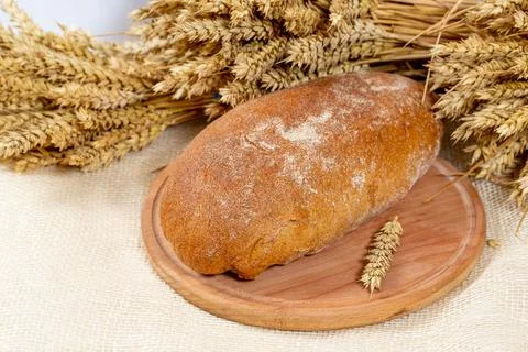 Black bread on the kitchen Board with wheat spikelets Stock Photos