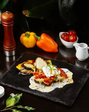 Black bread with melted cheese and tomatoes on it Stock Photos