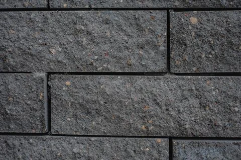 Black brick wall texture. Aged stone block masonry. Dark gloomy background Foto stock