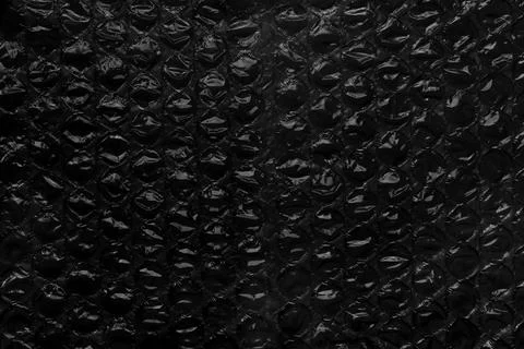 Black bubble wrap texture. Aged packaging material. Dark grunge abstraction Foto stock