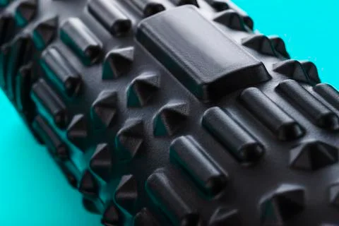 Black bumpy foam massage roller, body roller on blue background. F 写真素材