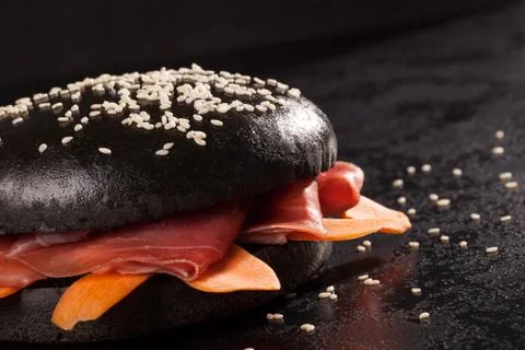 Black burger on dark background. Stock Photos