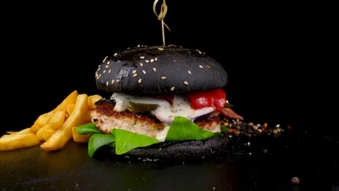Black Burger with meat and bacon, served with Fried Potato wedges Stock Footage 84652178