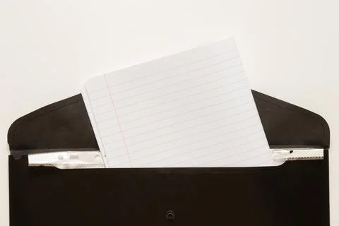 Black business folder with inserted school notebook in a line on a white ba.. Stock Photos