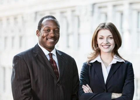 Black business man and caucasian business woman together in front of an older Stock Photos