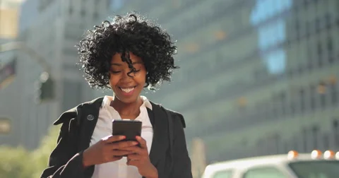 Black business woman in New York City texting cell phone Stock Footage