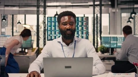 Black businessman, analytics on laptop, performance metrics, modern office Stock Footage 329323894