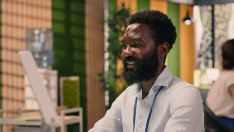 Black businessman, analytics on laptop, performance metrics, modern office Stock Footage 329325412