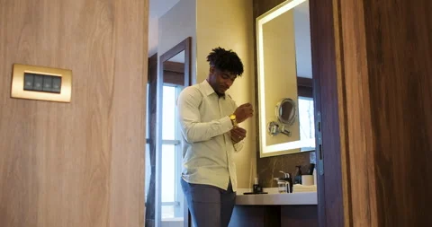 Black businessman getting ready for work while standing in bathroom in fron.. Stock Footage 336187329